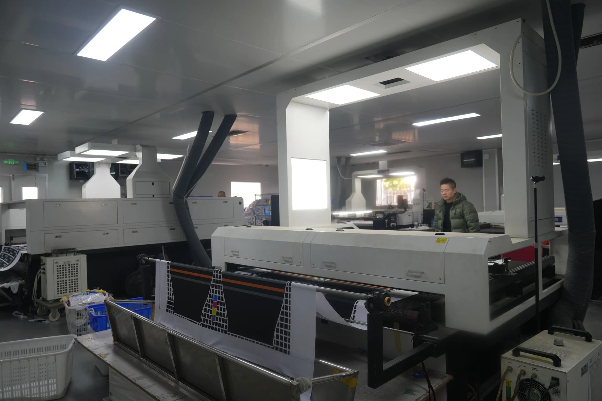 Computer-controlled cutting equipment and workstations in TONTON's sportswear factory