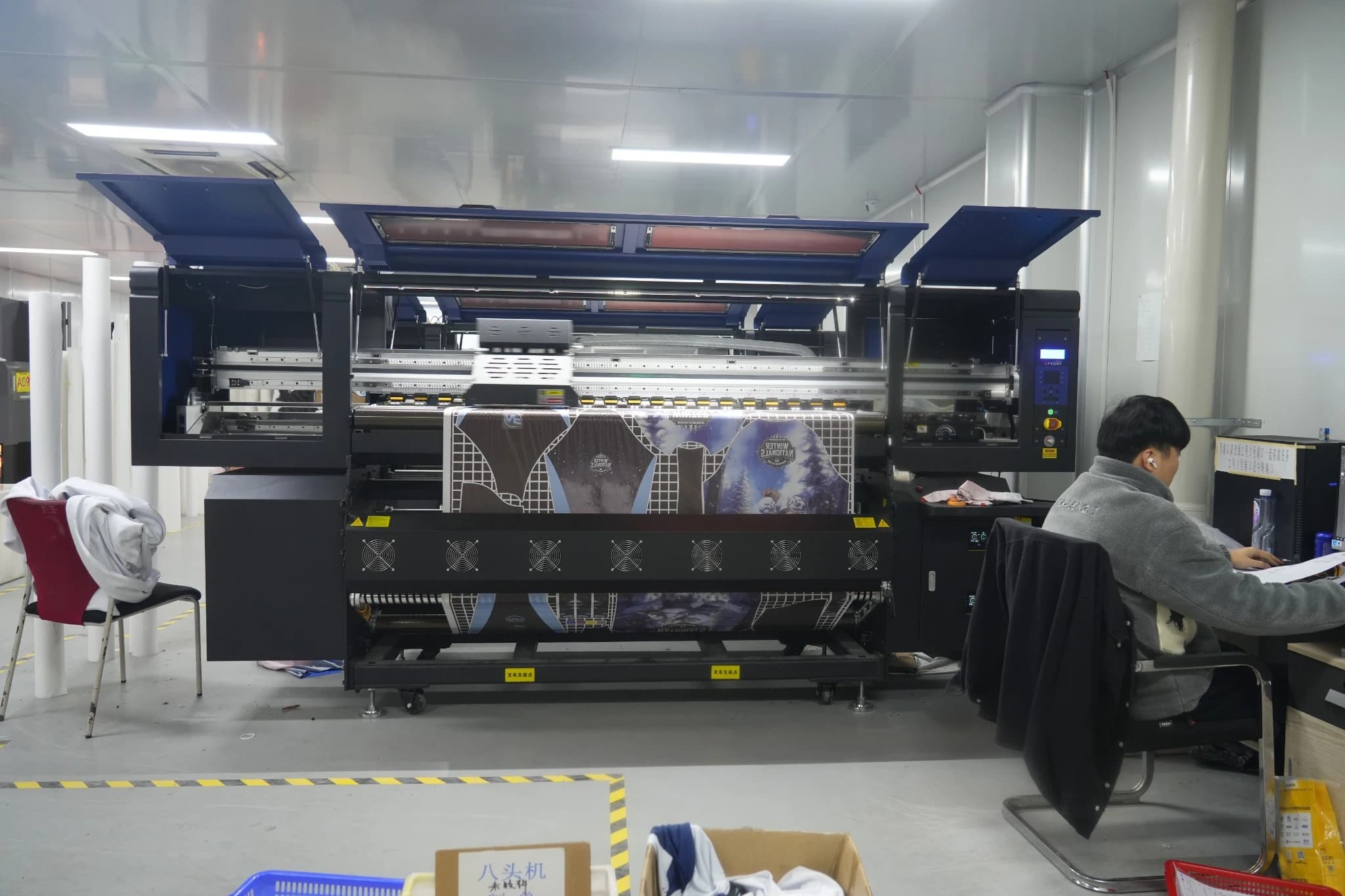 TONTON printing equipment with a team member working at the adjacent computer station