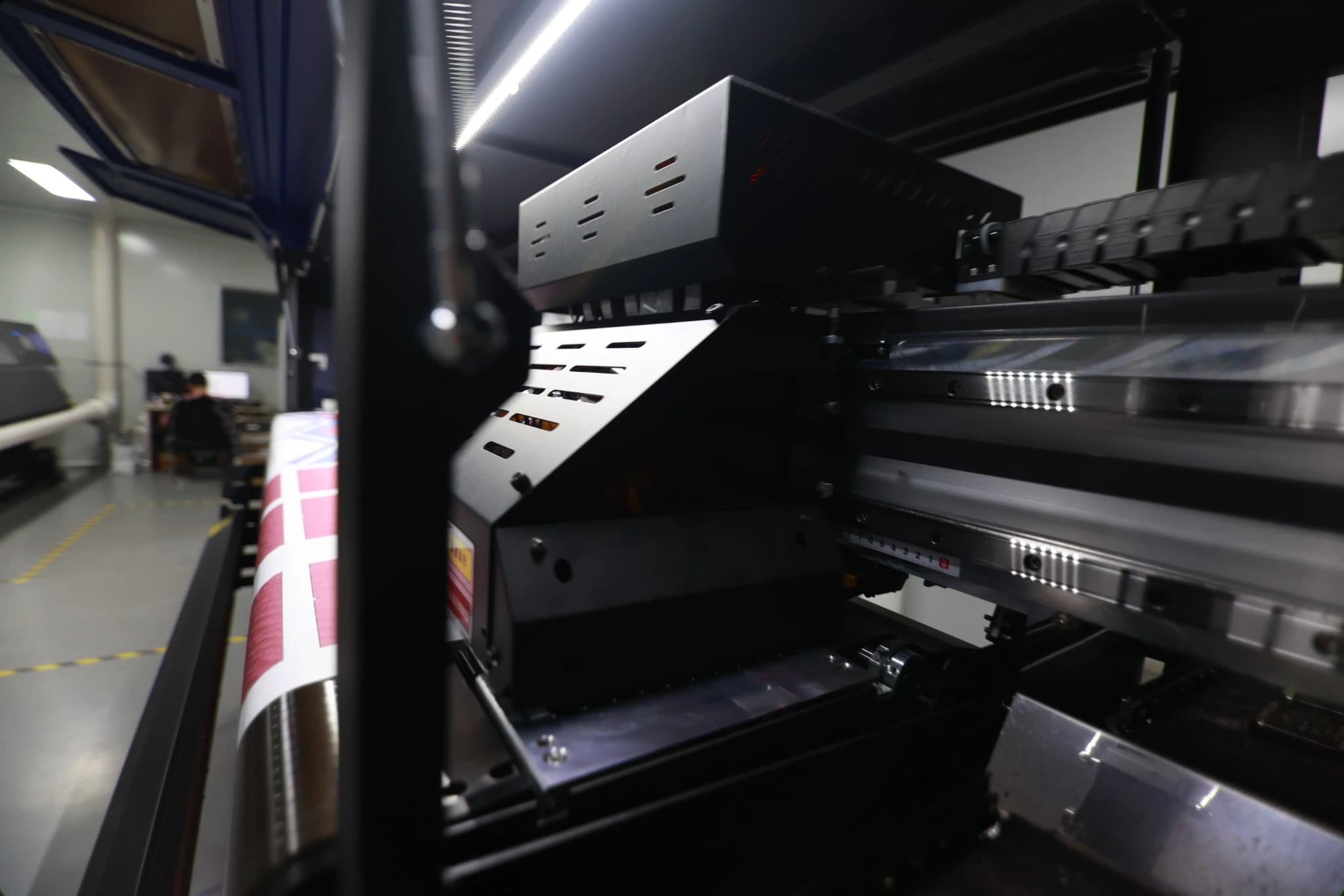 Close view of the printer carriage and rail in TONTON’s sublimation printing department