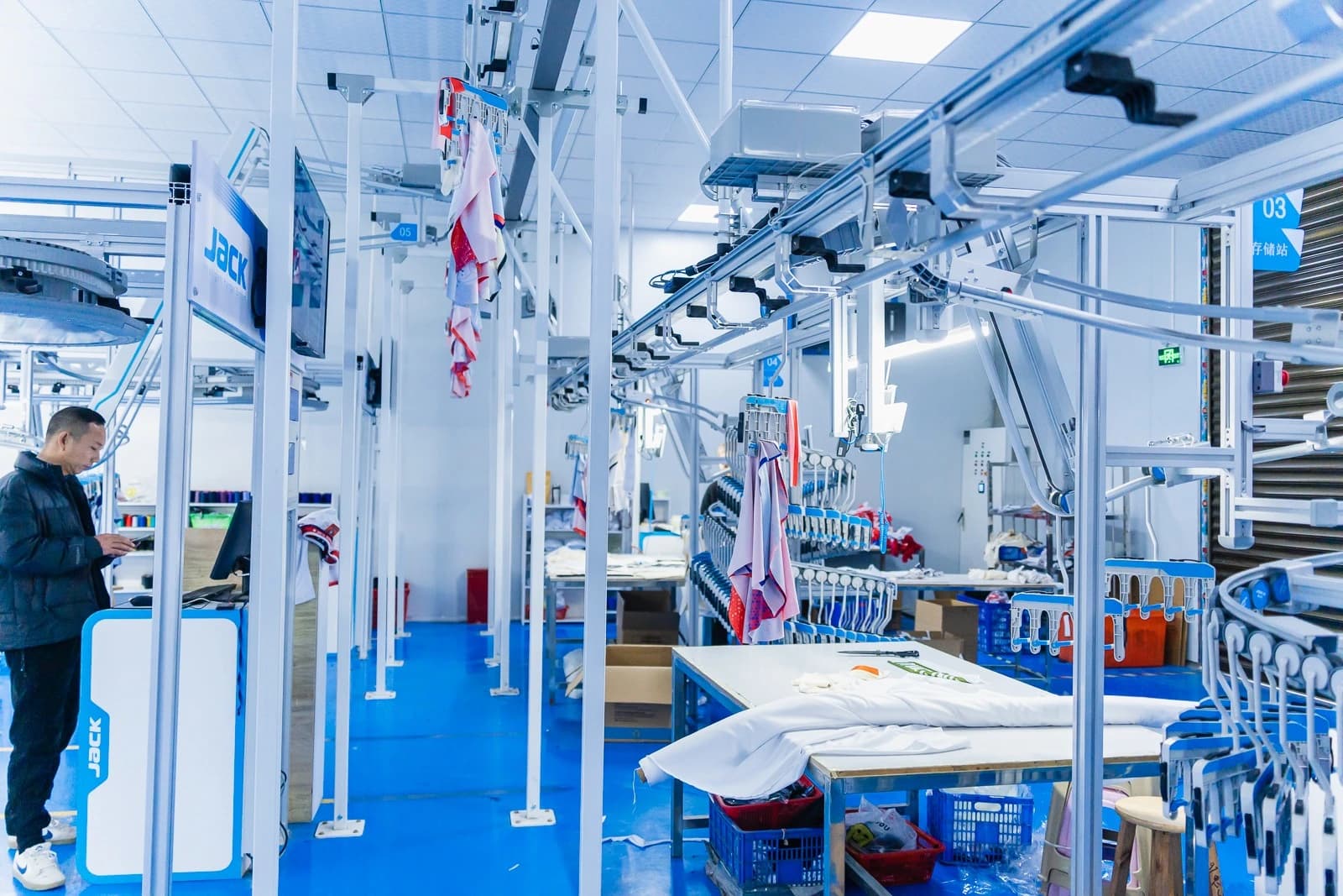 Overhead rails and routing connections above garment workstations
