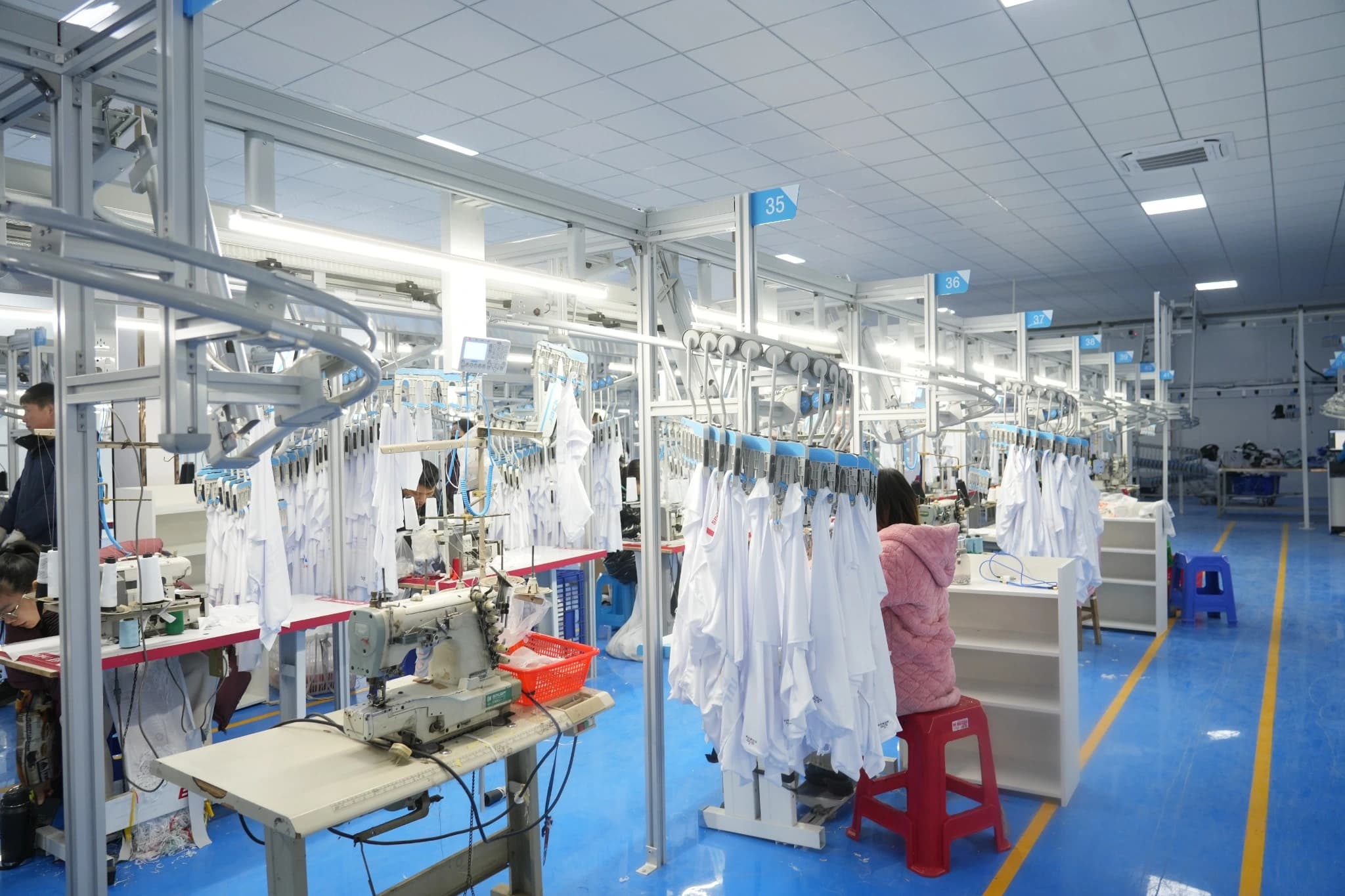 Sewing workstations arranged beneath TONTON's overhead garment transport rails