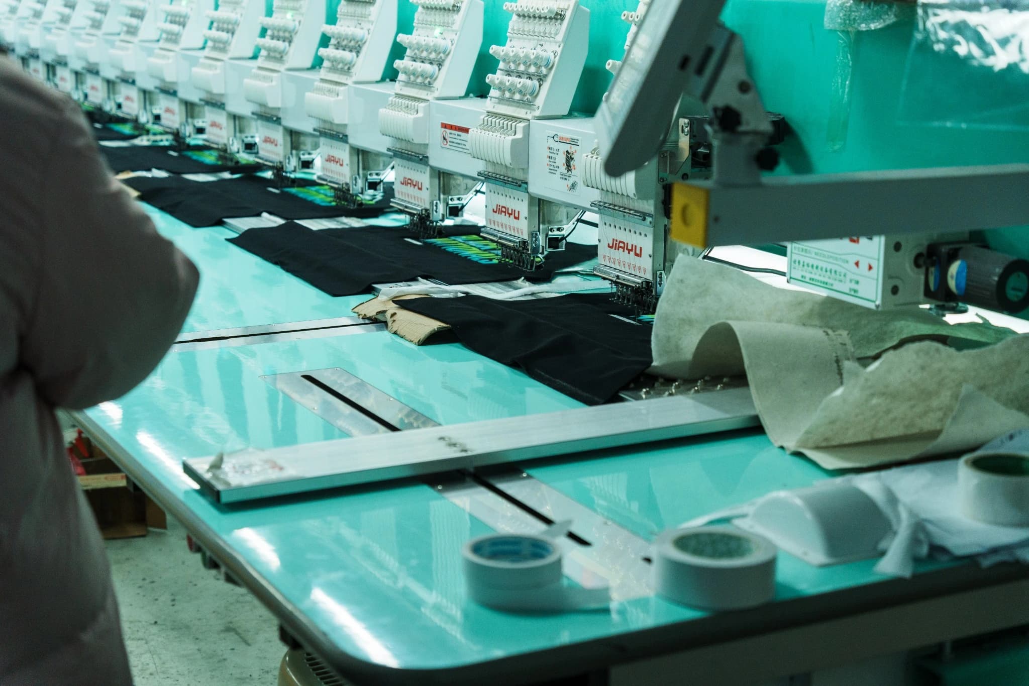 TONTON operator preparing material at an embroidery workstation