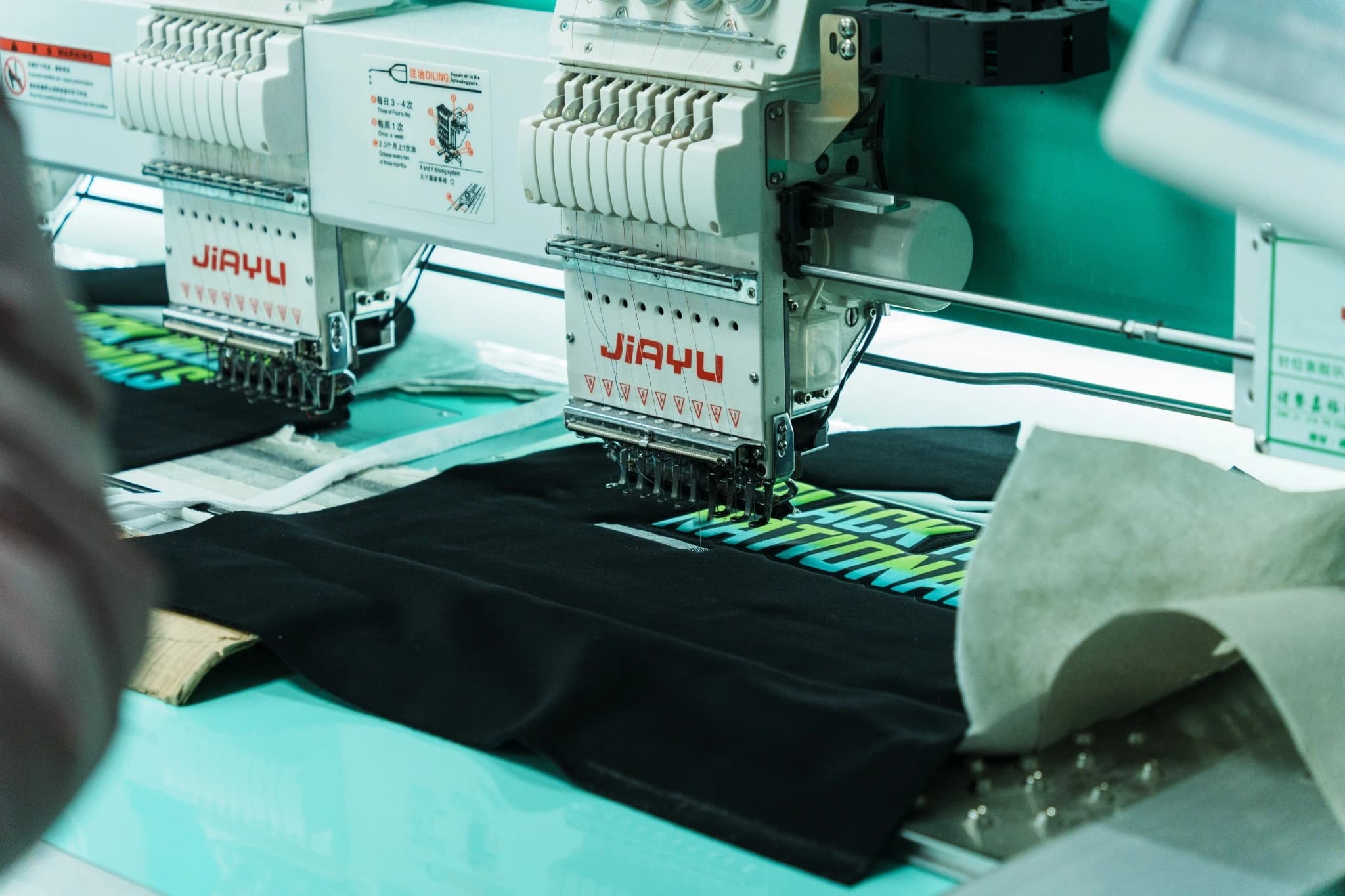 JIAYU embroidery heads working over dark sportswear panels at TONTON