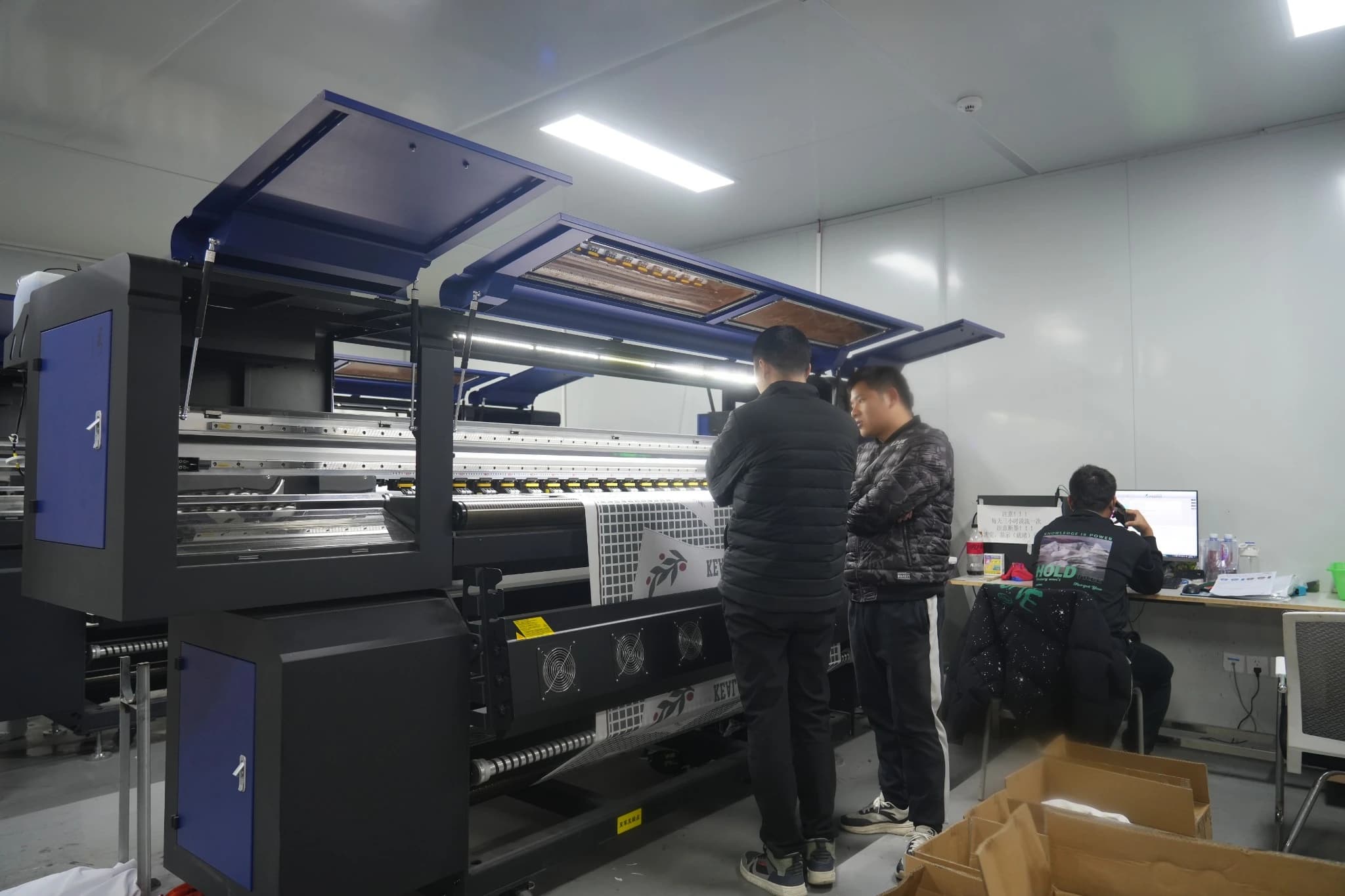 TONTON team members working beside digital printing equipment