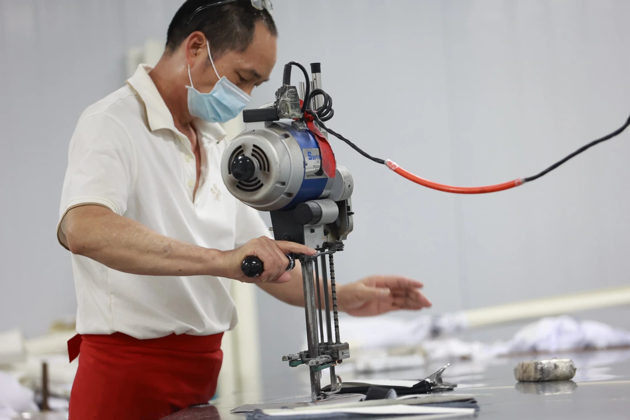 TONTON operator with an electric straight knife fabric cutting machine