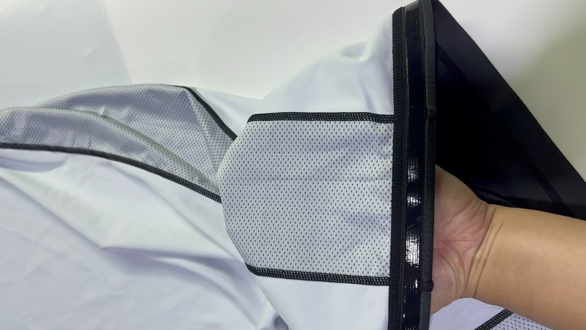 Actual supplied garment panel held open to display the mesh insert and neighboring fabric