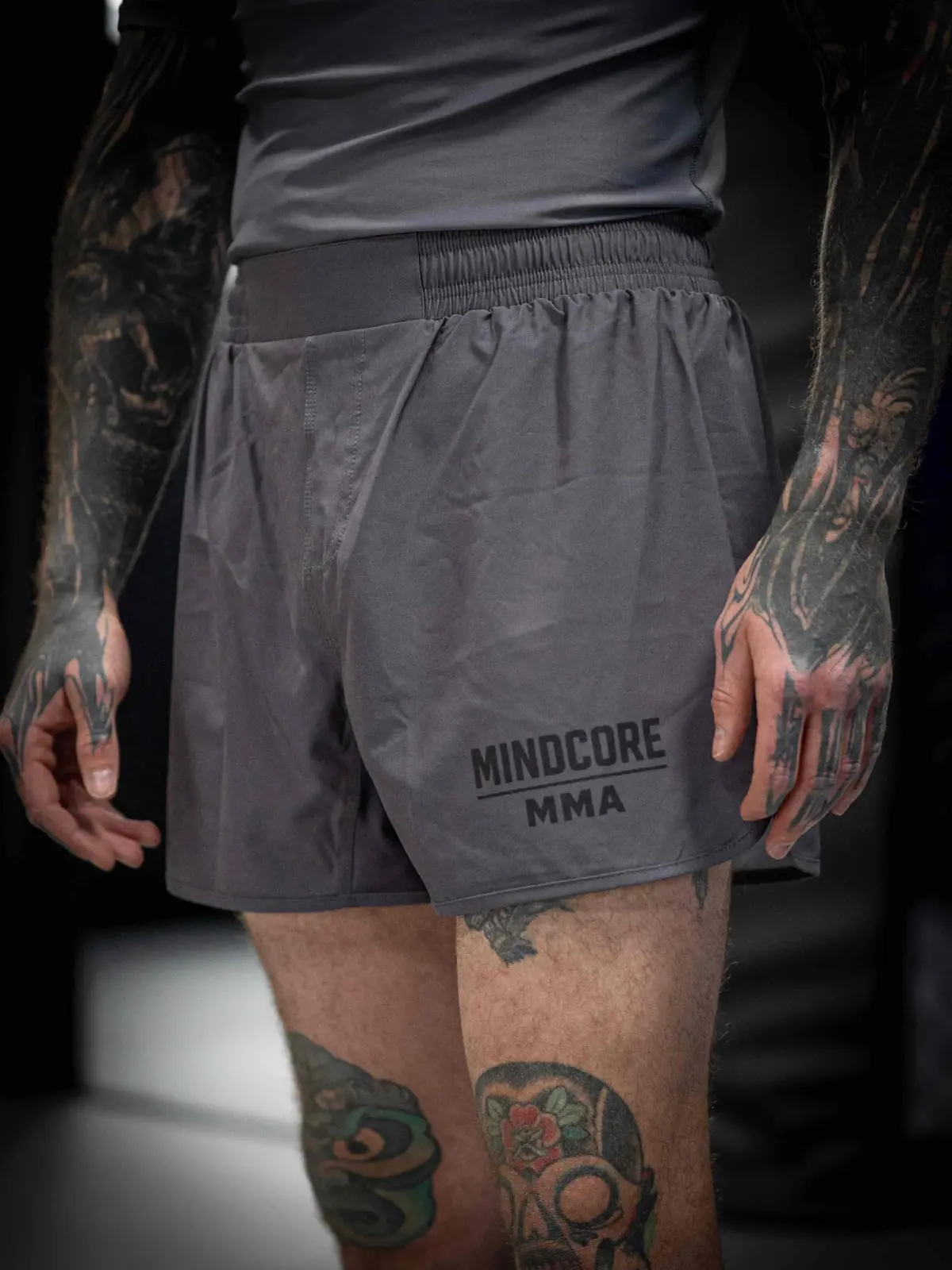 Customer athlete wearing grey Mindcore MMA training shorts with a broad elastic waistband