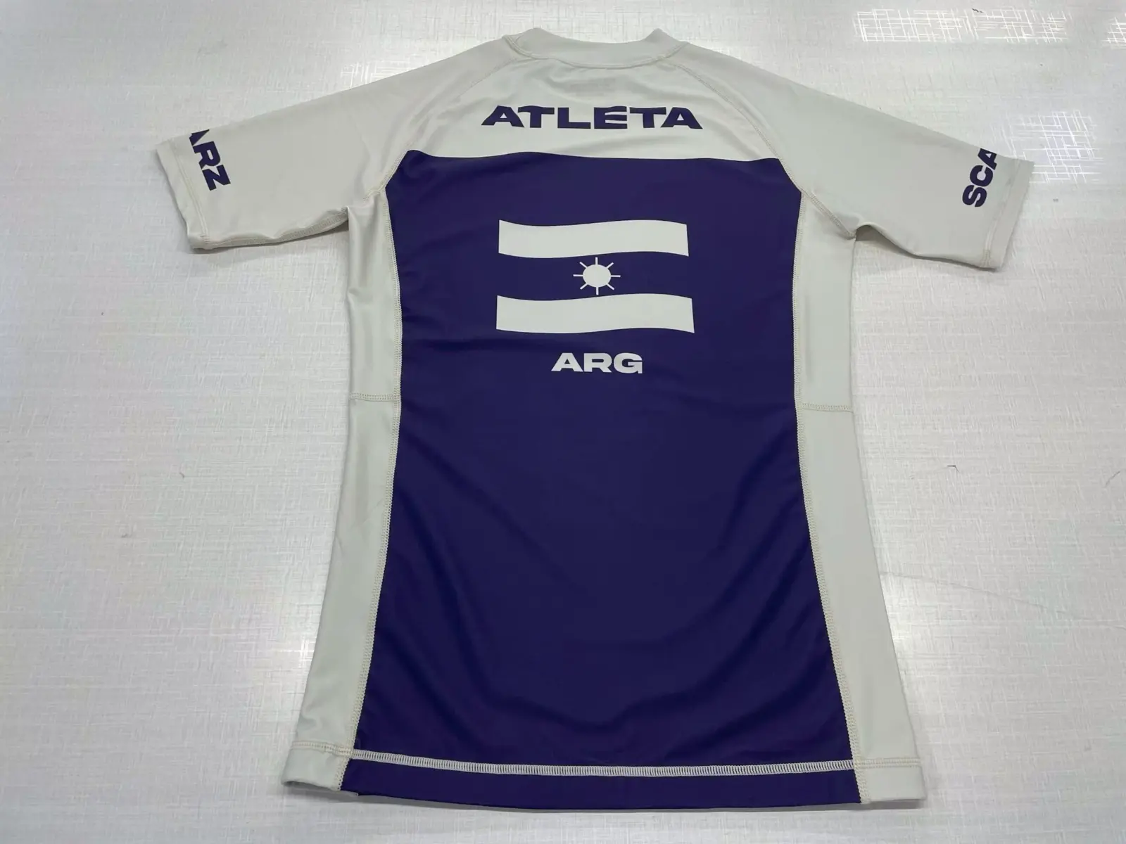 Customer-supplied front photograph of a finished white and purple Scarz long-sleeve custom Rash Guard