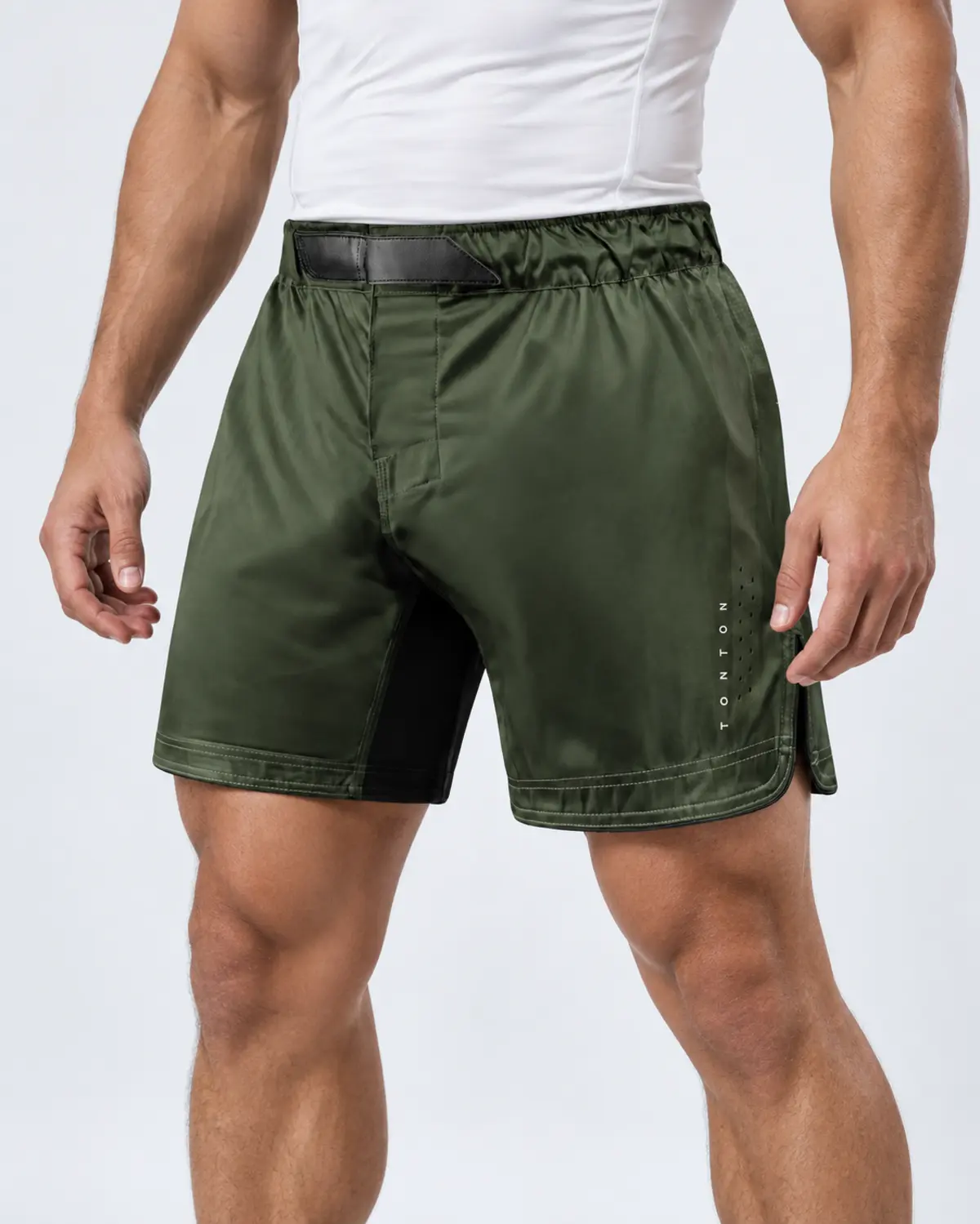Athletic male model wearing olive green custom training shorts in a studio