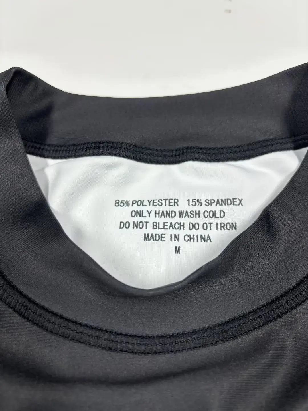 Rash Guard care label showing 85 percent polyester and 15 percent spandex