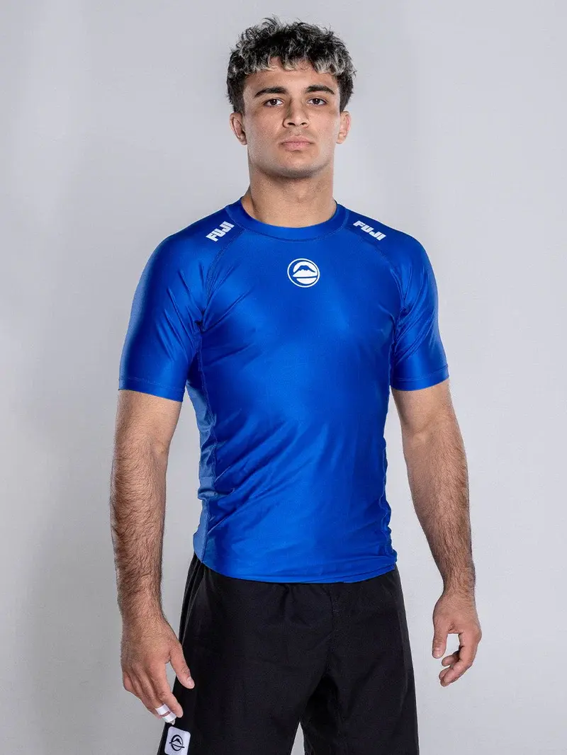 Front view of the blue short-sleeve Elite Team Rash Guard worn by an athlete
