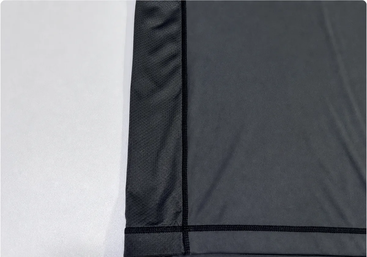 Rash Guard mesh panel joined to stretch body fabric with aligned seams and lower hem