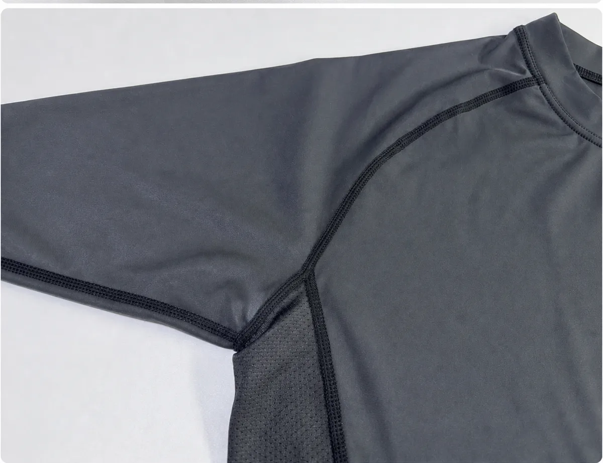 Close-up of flatlock stitching joining the raglan sleeve, body and mesh panel of a Rash Guard