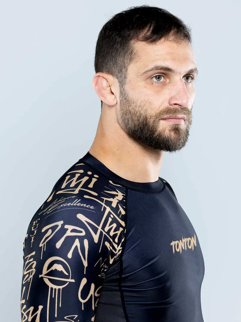 Shoulder and sleeve fit on a black and gold BJJ Rash Guard