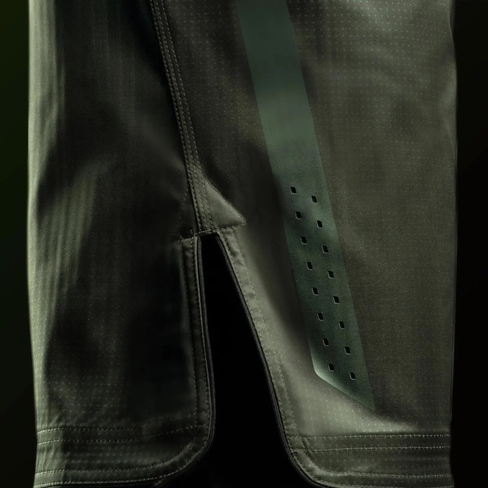 Close-up of side opening, perforated panel and reinforced hem stitching on training shorts